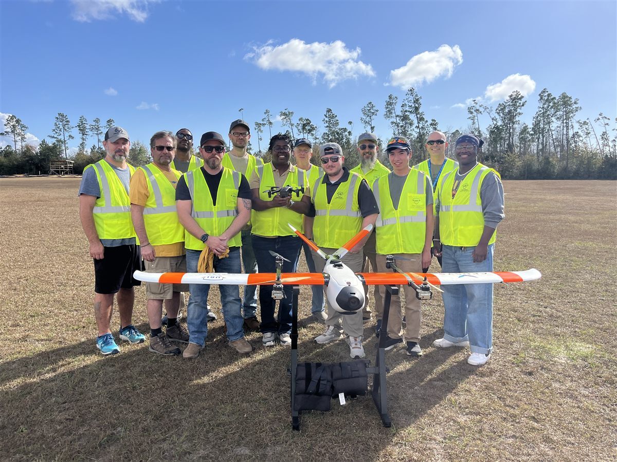UAS operations team in safety vests with a fixed-wing aircraft