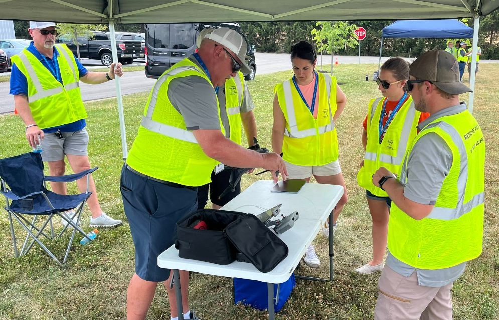 Safety-vested UAS team conducting a field operations briefing